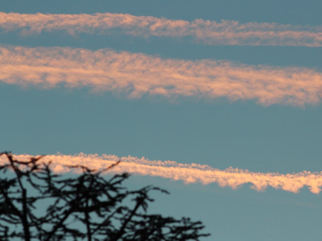Traînées d'avion au soleil couchant